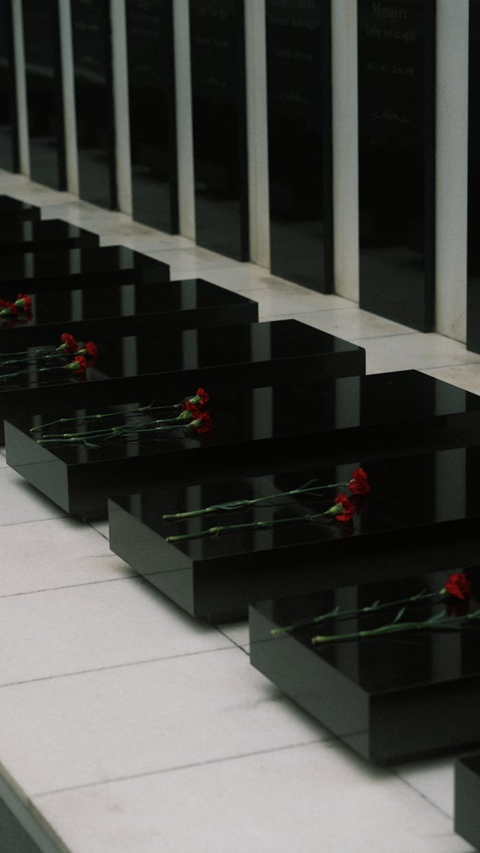 Elegant black marble tombstones adorned with red roses at a cemetery in Baku, Azerbaijan.